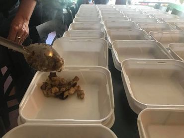 Stacks of containers ready to carry warm, dignified meals to anyone who needs a plate.