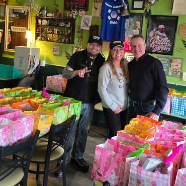 Teamwork makes it happen—smiling faces ready to distribute holiday care packages. The Ladenburgs