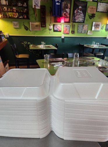 Stacks of containers ready to carry warm, dignified meals to anyone who needs a plate.