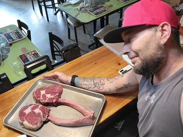 Chef Shawn Tibbitts preparing a private dinner for two featuring tomahawk steaks and chef-present hospitality.